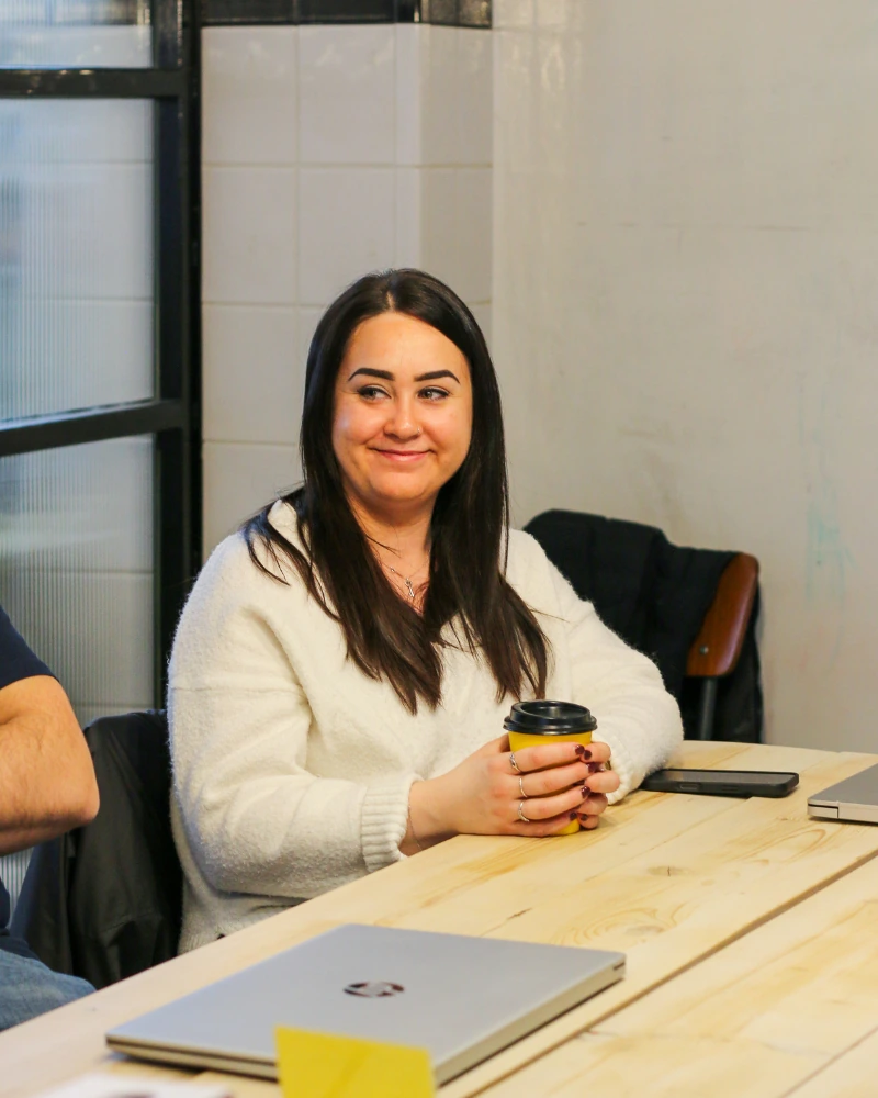 Woman holding a coffee cup during a meeting at IWN Accountancy